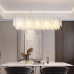 Підвісна овальна золота люстра із білими скляними пір'їнами у корпусі 100х40 см